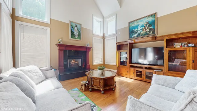 a living room with furniture a flat screen tv and a fireplace