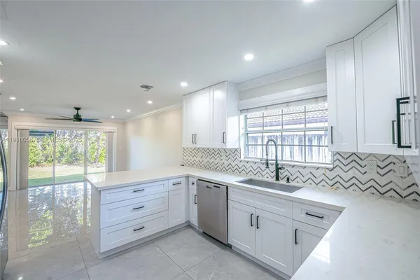 a large white kitchen with a large window