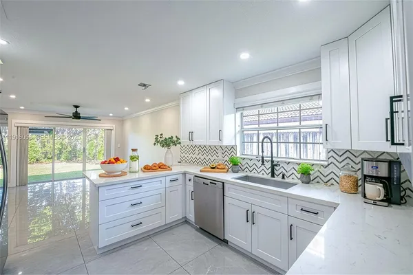 a kitchen that has a lot of cabinets in it and wooden floor