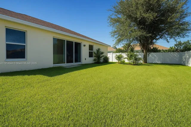 a view of a house with a big yard and large trees
