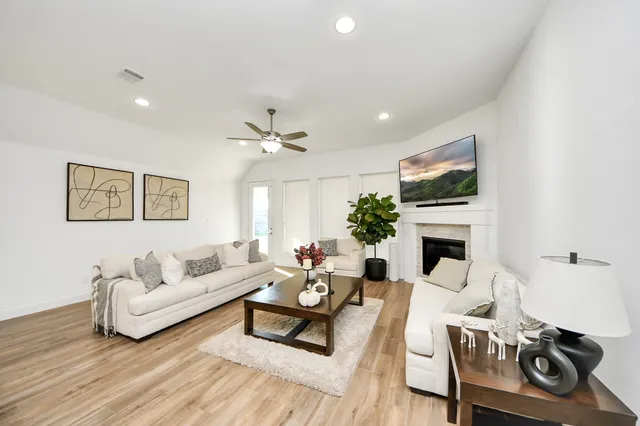 a living room with furniture a fireplace and a flat screen tv