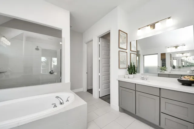 a bathroom with a tub a sink and mirror