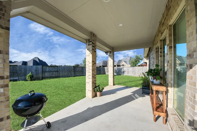 a view of a porch with furniture and a yard