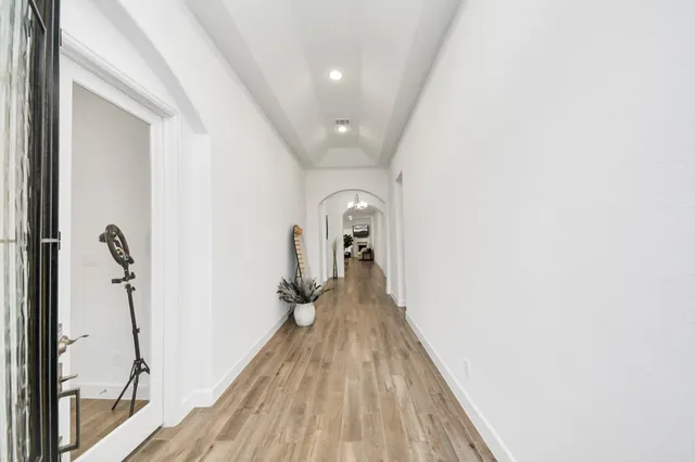 a view of a hallway with wooden floor and staircase