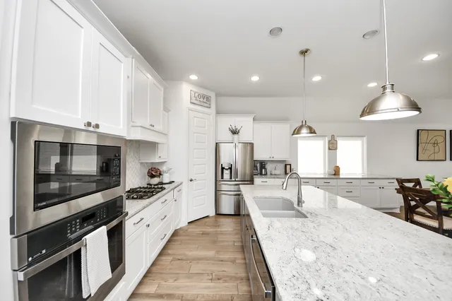 a large kitchen with stainless steel appliances granite countertop a stove and a sink