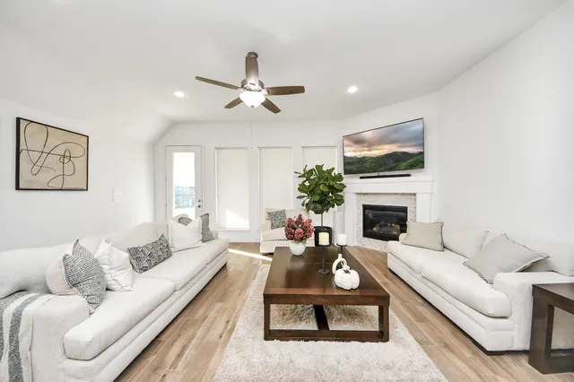 a living room with furniture a fireplace and a flat screen tv