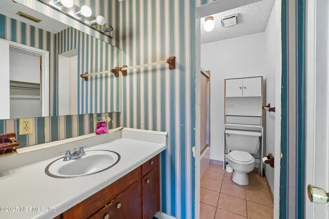 a bathroom with a sink a toilet and a mirror