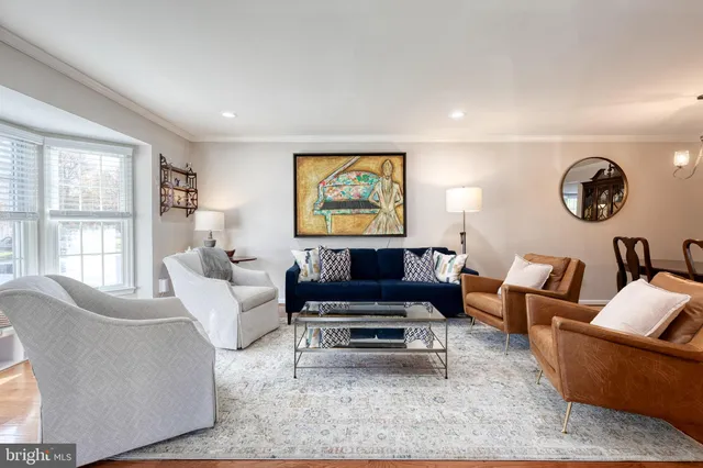 a living room with furniture a rug and a large window