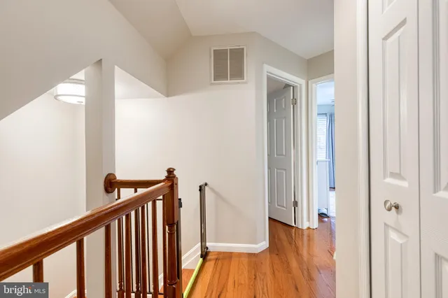 a view of a hallway with wooden floor and staircase