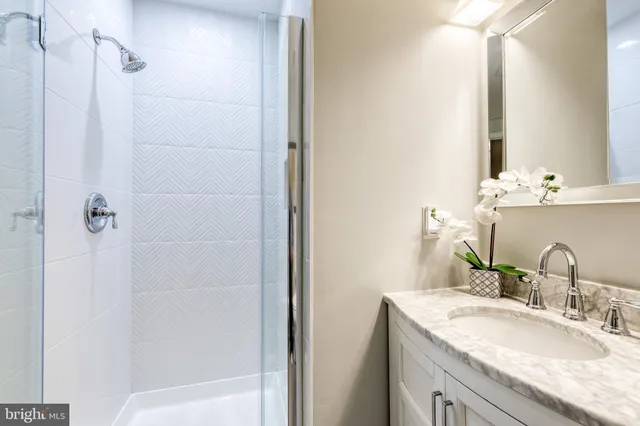 a bathroom with a granite countertop sink and a mirror
