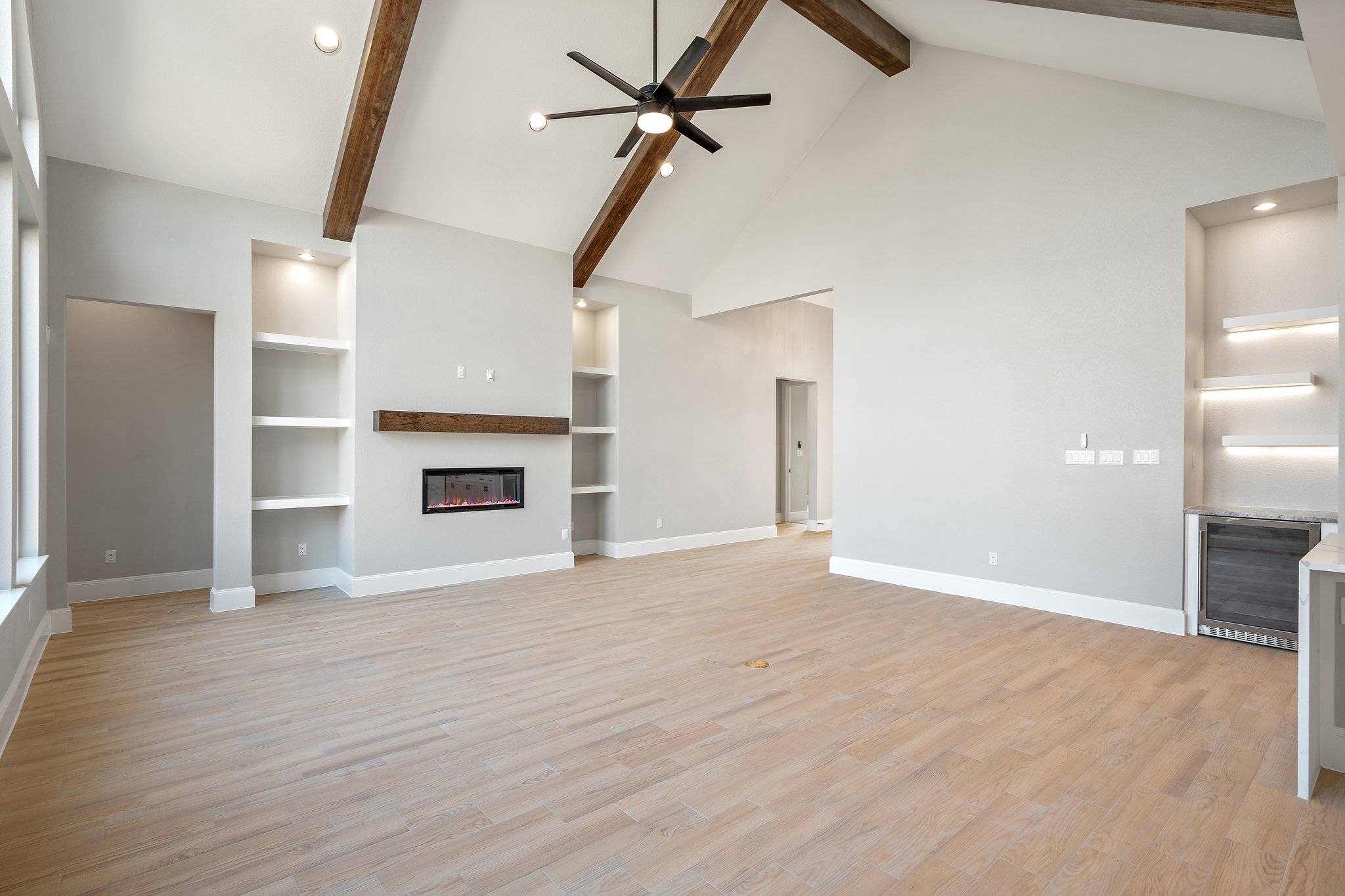 308 Axis Loop Georgetown, TX 78628 - Photo 12 of 40 an empty room with wooden floor a ceiling fan a fireplace and windows