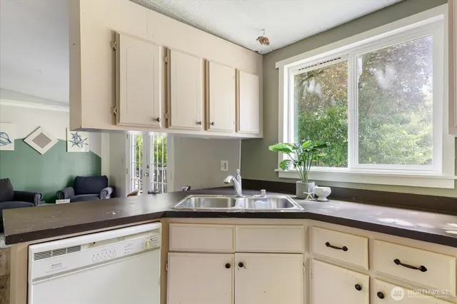 a kitchen with stainless steel appliances white cabinets and a window