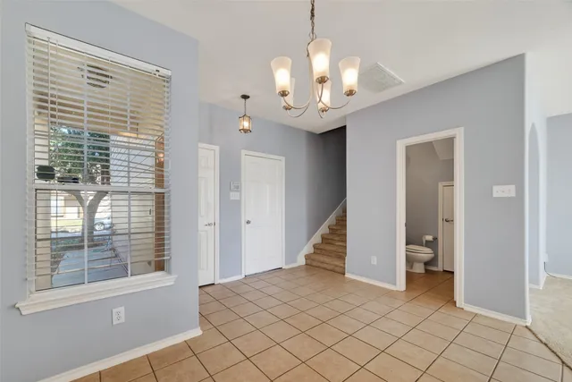 a view of a spacious bedroom with a large bed and a chandelier