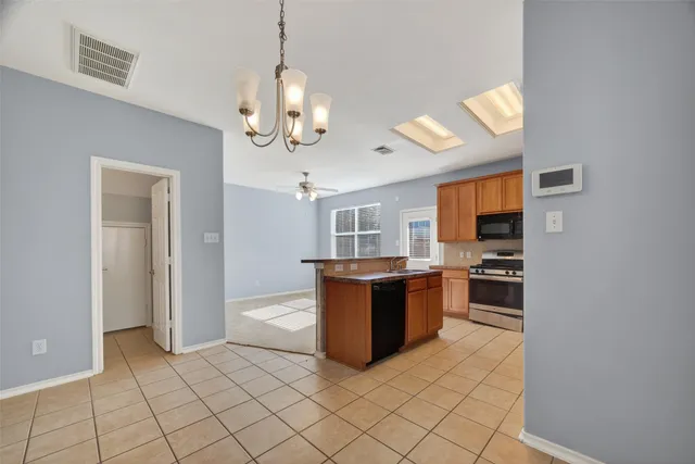 a kitchen with stainless steel appliances granite countertop a refrigerator and a stove top oven