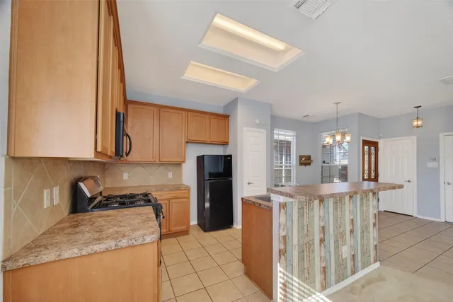a kitchen with stainless steel appliances granite countertop a refrigerator a sink and a stove