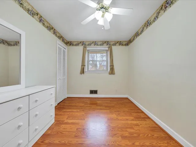 a view of empty room with window and ceiling fan