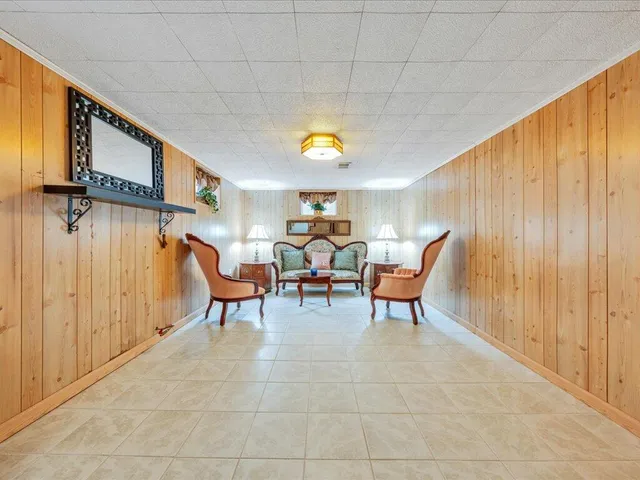 a living room with furniture a chandelier and a window