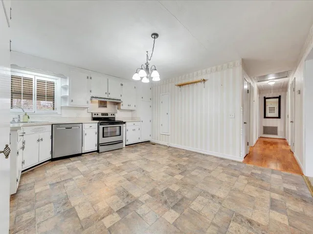 a view of a kitchen with a stove cabinets and a chandelier