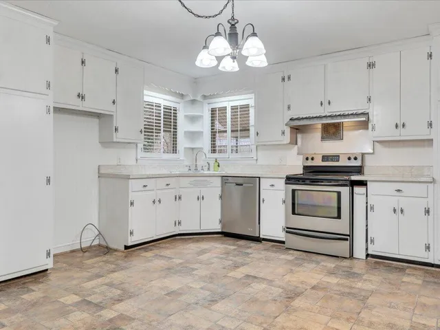 a kitchen with cabinets stainless steel appliances and a window