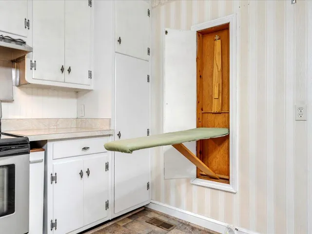a kitchen with granite countertop white cabinets and sink