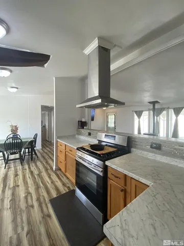 a kitchen with granite countertop a stove a sink and a refrigerator