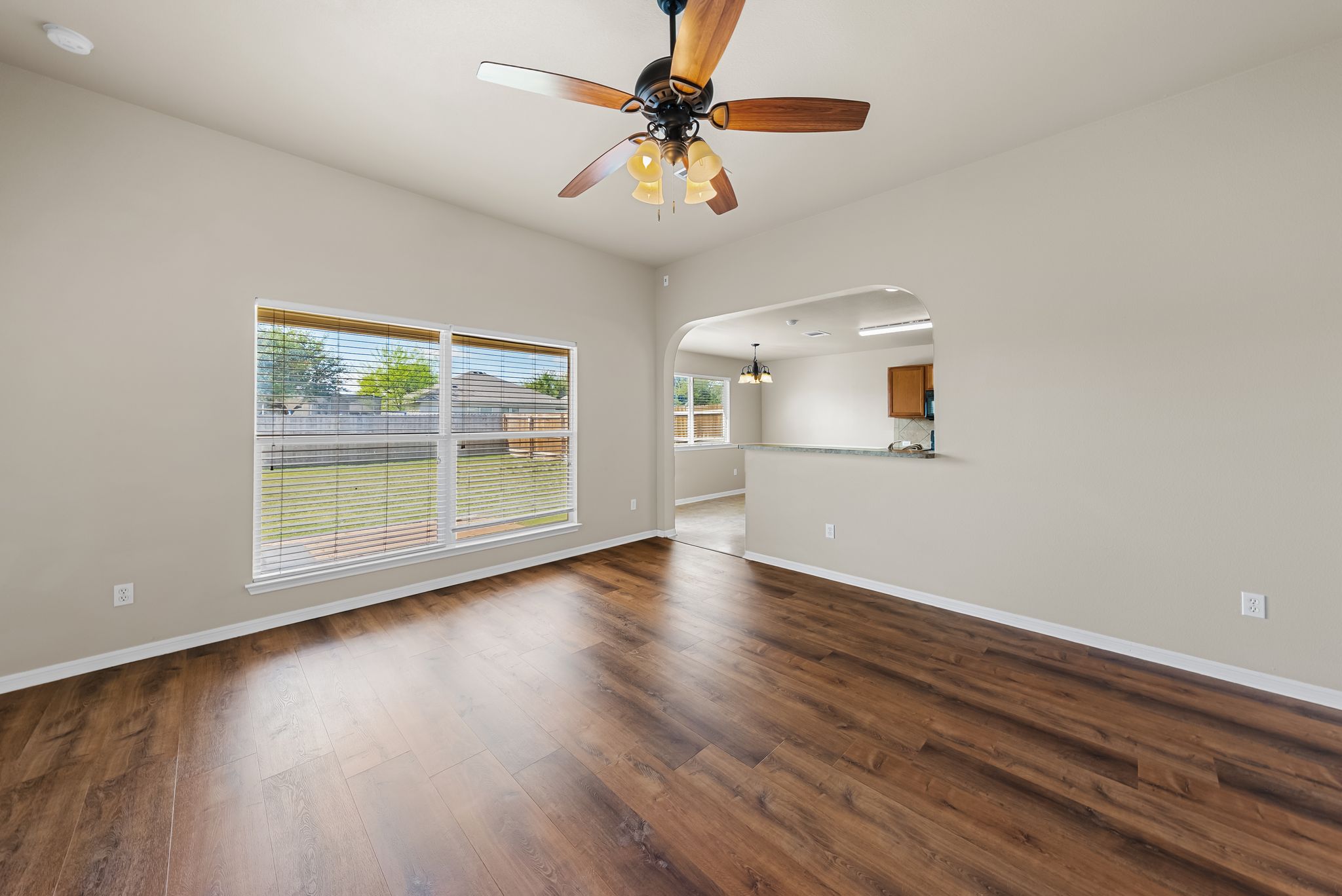 7719 Fieldstone Drive Temple, TX 76502 - Photo 13 of 37 Unfurnished living room featuring arched walkways, dark wood-style floors, and ceiling fan