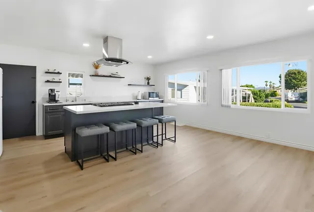 a kitchen with kitchen island a dining table and chairs