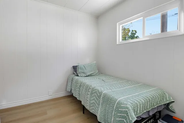 a bedroom with a bed and painting on the wall