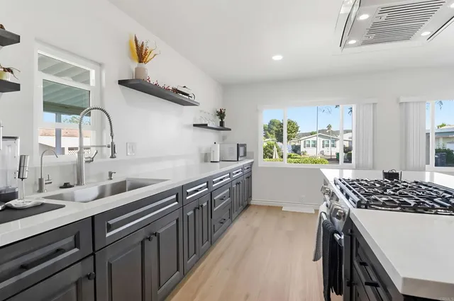 a kitchen with stainless steel appliances a sink stove and cabinets