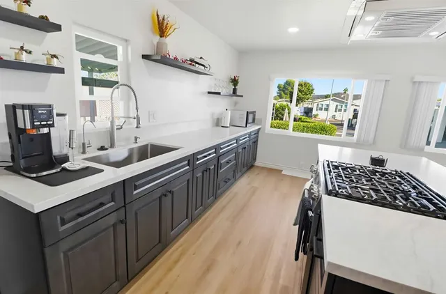 a kitchen with stainless steel appliances a sink stove and cabinets