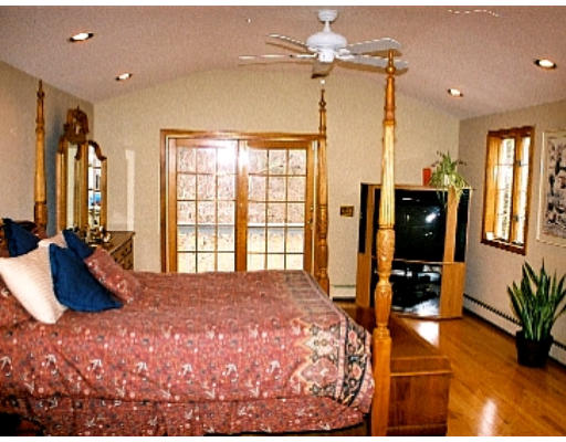38 R County Road Andover, MA 01810 - Photo 4 of 4 a large bedroom with a bed dresser and a chandelier