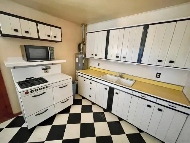 a kitchen with a stove a sink and a microwave