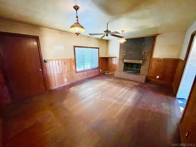 a view of empty room with fireplace and fan