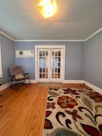 a view of a livingroom with wooden floor and furniture