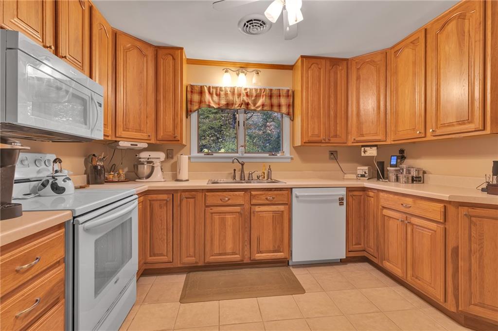 124 Heath Drive Baden, PA 15005 - Photo 9 of 38 a kitchen with a sink window and cabinets