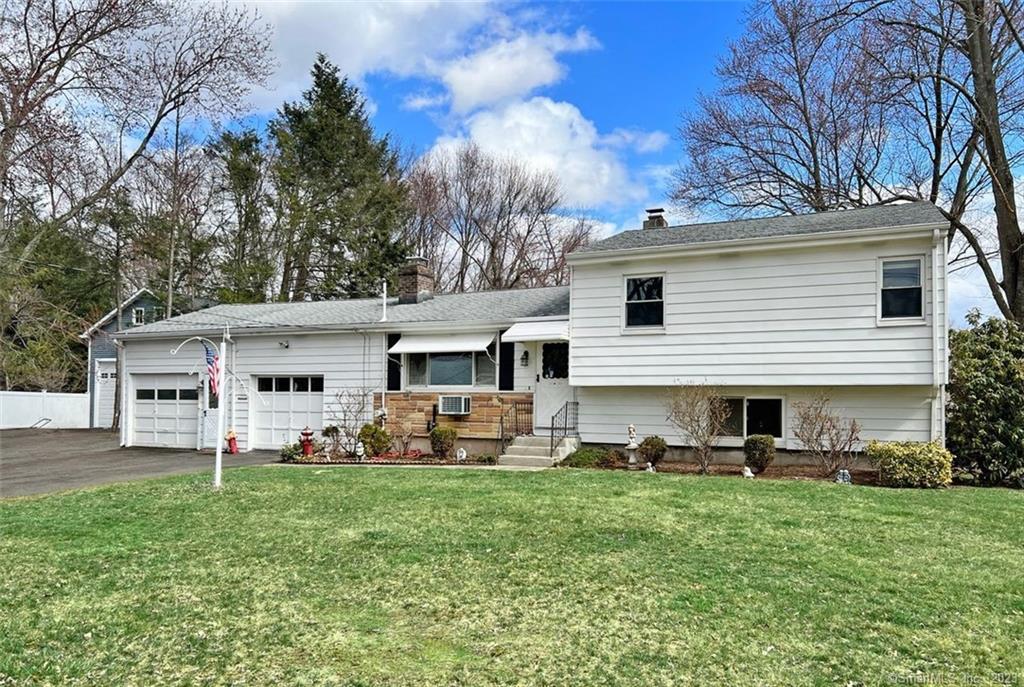 a front view of house with yard and trees in the background