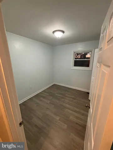 en empty room with wooden floor and window