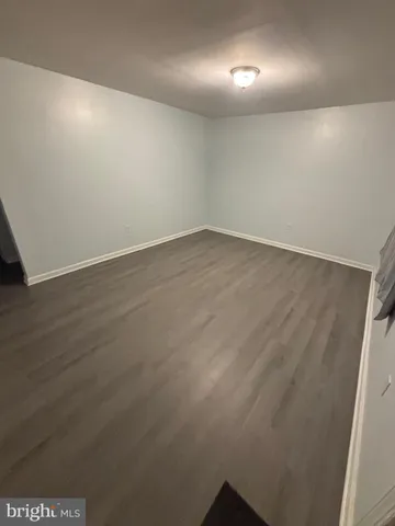 an empty room with wooden floor & windows