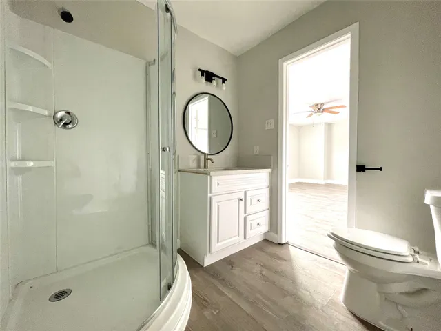 a bathroom with a granite countertop toilet sink and mirror