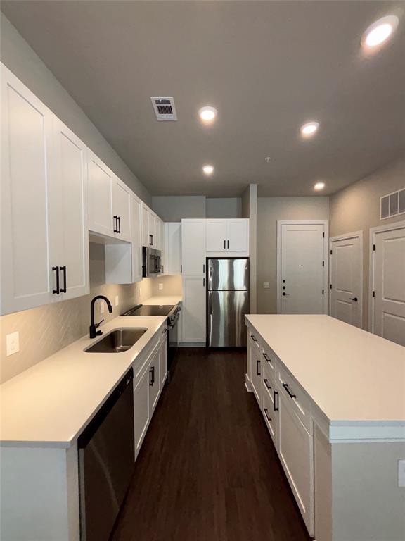 a kitchen with stainless steel appliances a sink stove and refrigerator