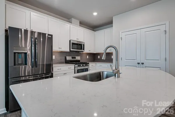 a kitchen with stainless steel appliances a refrigerator sink and microwave