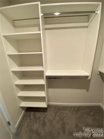 a view of walk in closet with empty racks
