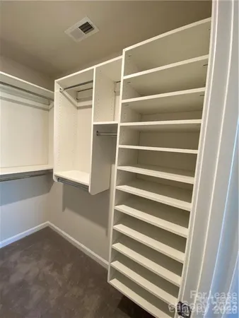 a view of walk in closet with empty racks