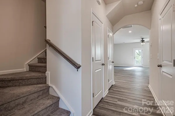 a view of a hallway with wooden floor and staircase
