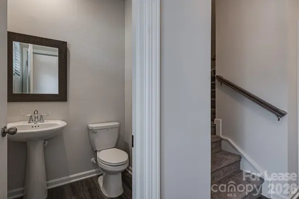 a bathroom with a toilet a sink and mirror