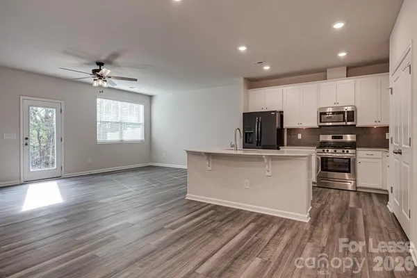 a kitchen with stainless steel appliances a refrigerator sink and microwave
