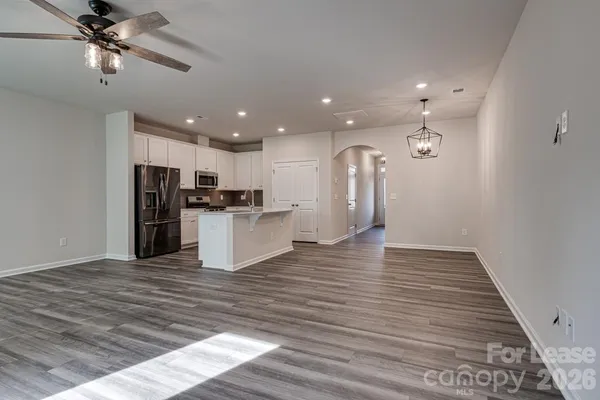 a view of a kitchen with a refrigerator and a stove top oven
