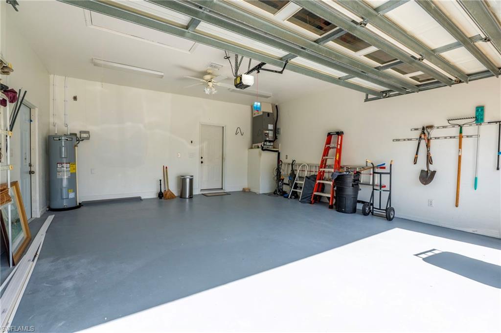 223 Stanhope Circle Naples, FL 34104 - Photo 37 of 41 Spacious garage featuring a durable floor coating, fluorescent lighting, a ceiling fan, and accessible utility connections