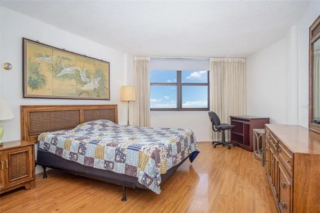 a bedroom with a bed table and a window