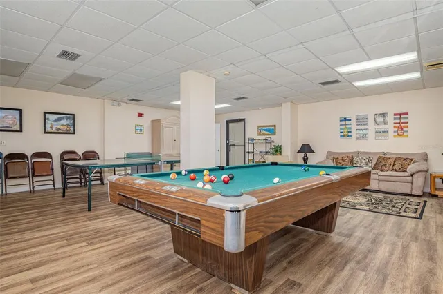 a room with pool table and windows